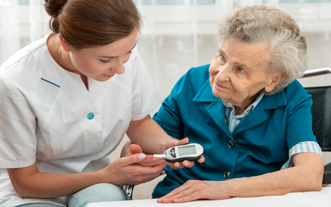 A nurse carefully examines an old woman's blood sugar levels to ensure her safety and well-being.