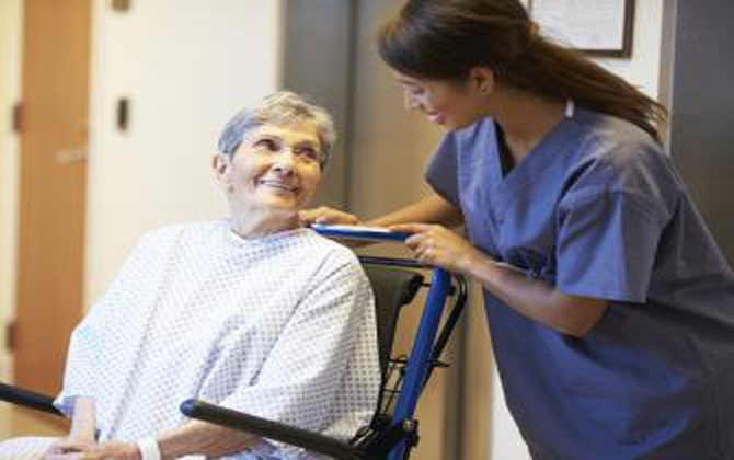 A home nurse is giving caring, professional care and support to an elderly woman in a wheelchair