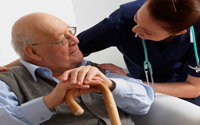 A female doctor talks to an elderly man with a walking stick, representing home care services.