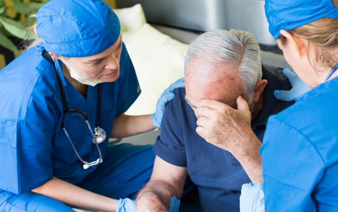 A healthcare provider compassionate care to an elderly guy receiving stroke treatment.