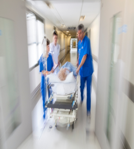 A patient was on a stretcher in a blurry hospital hallway, suggesting an urgent situation.