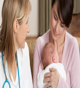 A mother holding her baby affectionately and carefully with a home care doctor sitting next to her