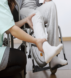 A healthcare professional giving psychological therapy to a dependent on a wheelchair woman