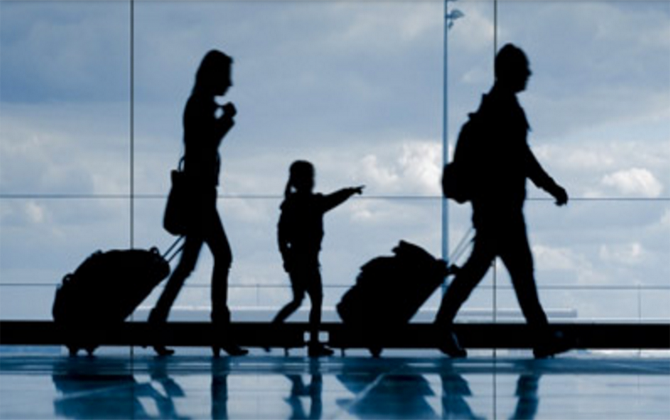 A window is a silhouette of a family of four, highlighting Travel Assistance Service